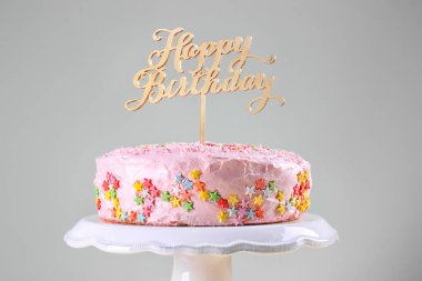 Lezzetli Doğum günü pastası ışık arka plan üzerinde stand