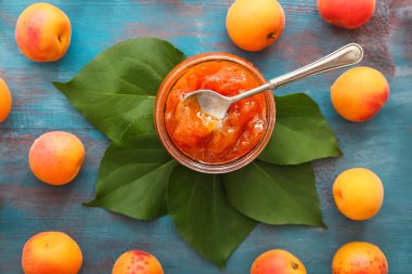 Cam kavanoz tatlı Kayısı reçeli ve ahşap masa üzerinde taze meyve