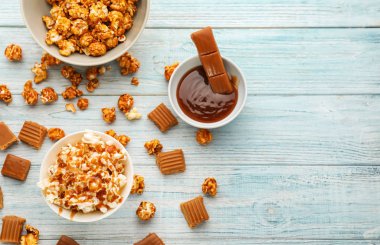 Ahşap arka plan üzerinde lezzetli karamelli patlamış mısır ile kompozisyon