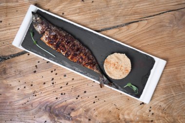 Lezzetli kızarmış balık ve ahşap masa üzerinde kuskus ile kayrak plaka