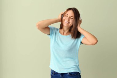 Kulaklıklı, müzik dinleyen güzel, genç bir kadın.