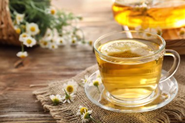 Ahşap masa üzerinde lezzetli papatya çayı fincan