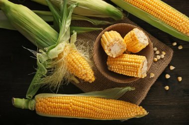 Ahşap masa üzerinde taze mısır koçanı ile kase