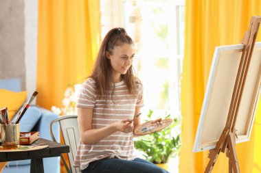 Atölyede resim yapan kadın sanatçı
