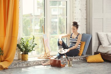 Pencere atölye üzerinde otururken kadın sanatçı resim resim