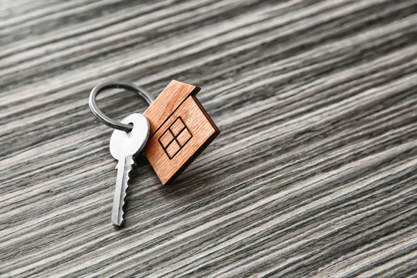 Llave Con Baratija Forma Casa Sobre Fondo Madera Concepto Hipotecario — Foto de Stock