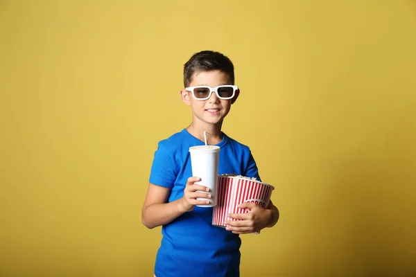 ポップコーンと飲み物映画館の メガネを身に着けている色の背景上のカップとかわいい男の子 — ストック写真