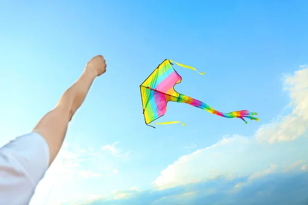 Woman flying kite in blue sky