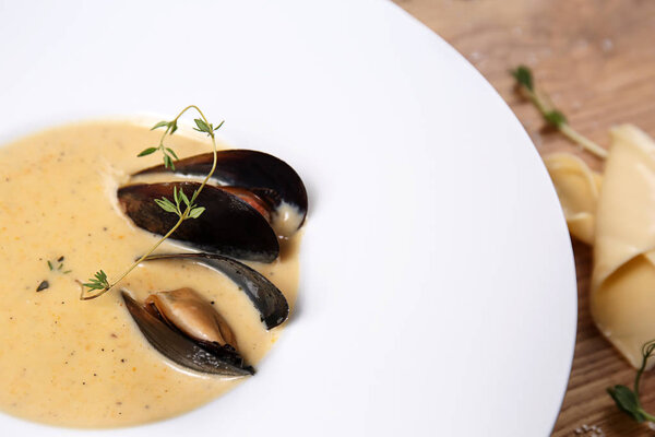 Вкусный суп с мидиями в тарелке, крупным планом
