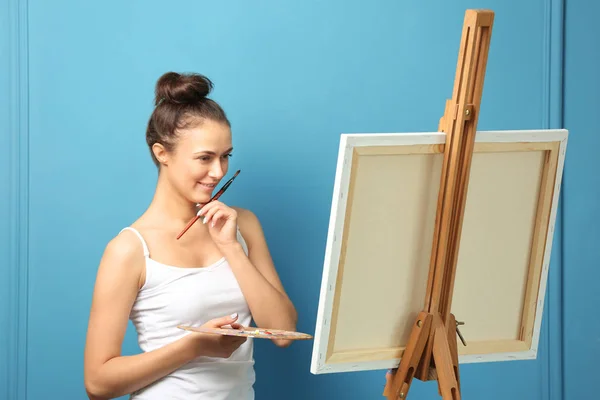 Female artist waiting for inspiration on color background