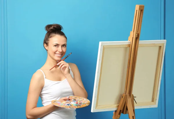 Female artist waiting for inspiration on color background