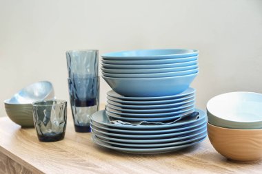 Seramik tabaklar, kaseler ve ahşap masa gözlük yığını