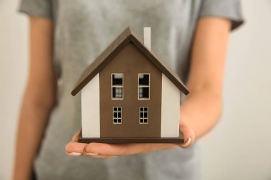 Ev modeli açık renkli, closeup tutan kadın. İpotek kavramı