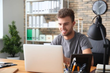 Laptop ofiste çalışan yakışıklı adam