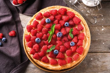 Ahşap masa üzerinde lezzetli frambuazlı cheesecake