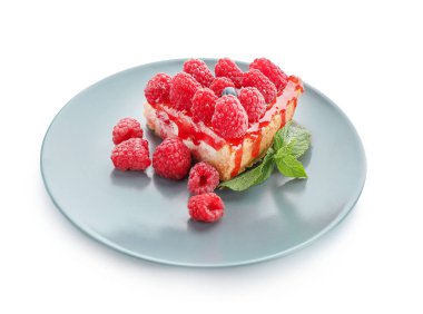 Beyaz zemin üzerine lezzetli frambuazlı cheesecake parçası ile plaka