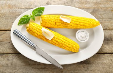 Plaka lezzetli mısır koçanı, tereyağı ve tuz ahşap tablo