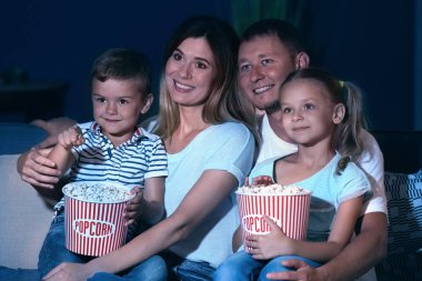 Mutlu aile akşam Tv izlerken patlamış mısır yemek