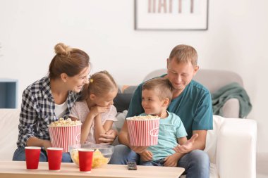 Evde Tv izlerken patlamış mısır yemek aile