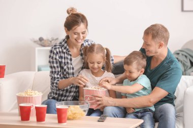 Evde Tv izlerken patlamış mısır yemek aile