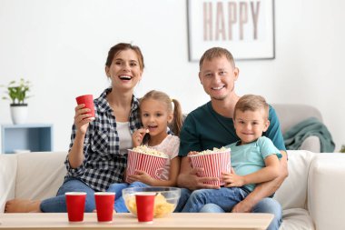 Evde Tv izlerken patlamış mısır yemek aile