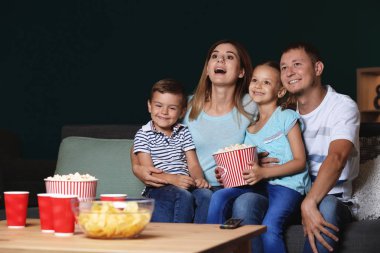 Mutlu aile akşam Tv izlerken patlamış mısır yemek
