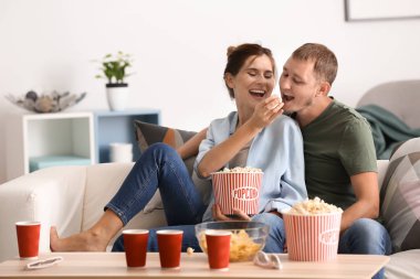 Çift evde Tv izlerken patlamış mısır yemek