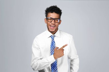 Gri arka plan üzerine bir şey işaret yakışıklı Afrikalı-Amerikalı iş adamı