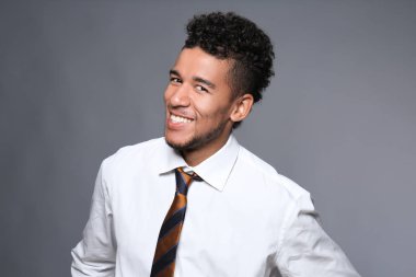 Yakışıklı Afrikalı-Amerikalı işadamı gri arka plan üzerinde