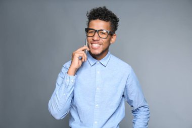 Yakışıklı Afrikalı-Amerikalı işadamı tarafından cep telefonu gri arka plan üzerinde konuşurken