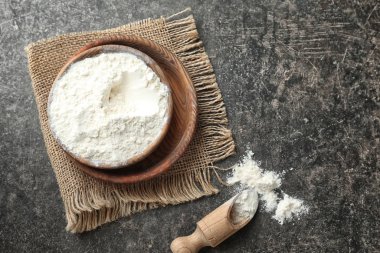 Gri arka plan üzerinde buğday unu ile kase