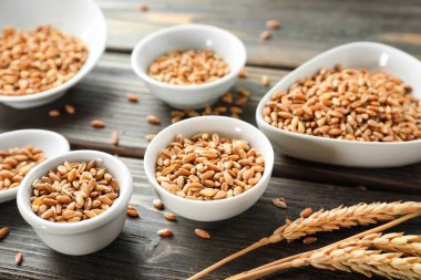 Tahta zemin üzerinde buğday taneleri olan kaseler