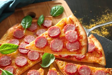 Kürek kullanarak lezzetli pizza Slice tahtasından alarak