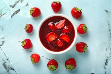 Işık tablosu üzerinde lezzetli çilek reçeli ile kase