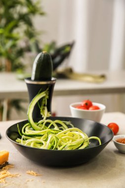 Mutfak masasının üzerinde kabak noodles ile kase
