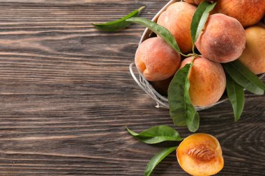 Sepet ve ahşap masa üzerinde taze şeftali