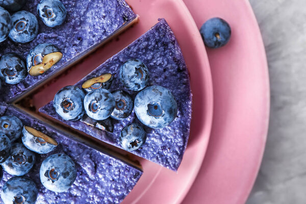 Тарелка с вкусным черничным чизкейком на столе, крупным планом
