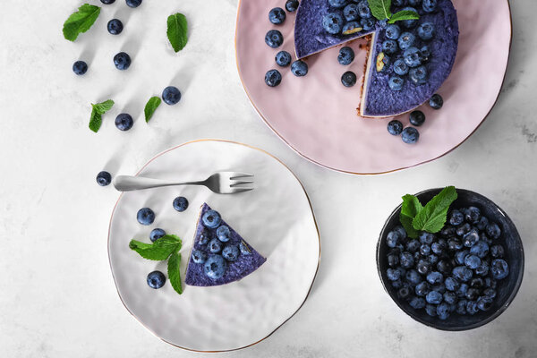 Тарелки с черничным чизкейком на белом столе
