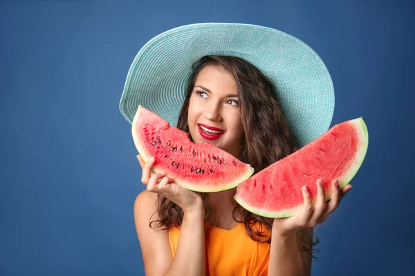 美丽的年轻妇女与切片的美味西瓜的颜色背景 — 图库照片