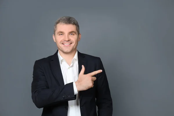 Hombre Negocios Guapo Señalando Algo Sobre Fondo Gris — Foto de Stock