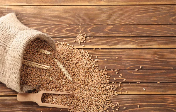 Bag Scattered Wheat Grains Wooden Background — Stock Photo, Image