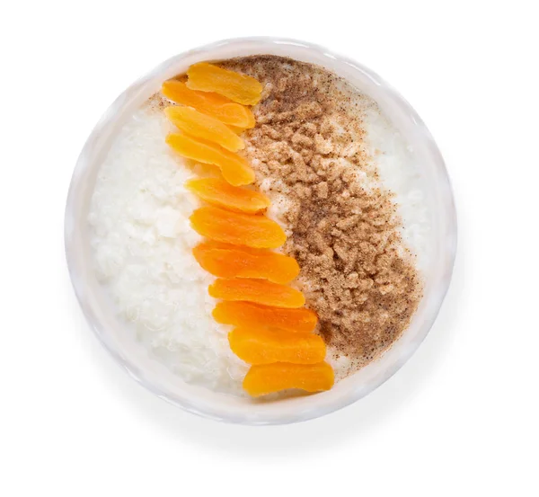 Bowl Delicious Rice Pudding Dried Apricot Cinnamon Powder White Background — Stock Photo, Image