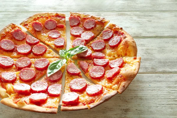 Ahşap masa üzerinde lezzetli dilimlenmiş pizza ile plaka