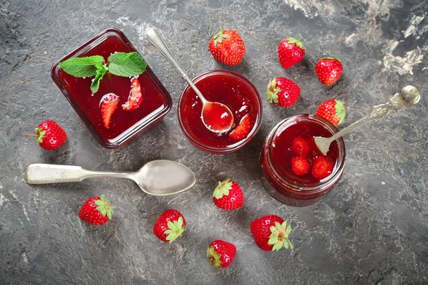 Glas Und Schalen Mit Leckerer Erdbeermarmelade Auf Grunge Tisch — Stockfoto