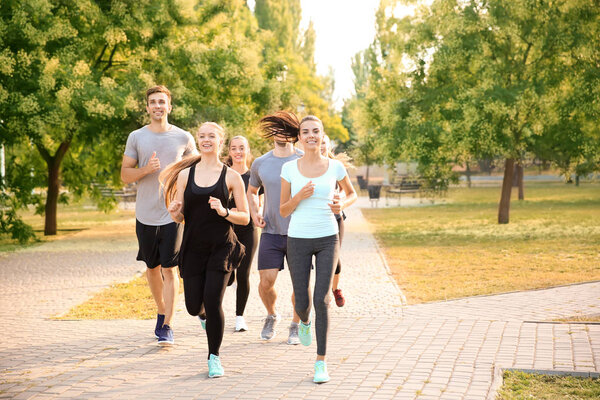 Группа спортивных людей, бегущих на открытом воздухе
