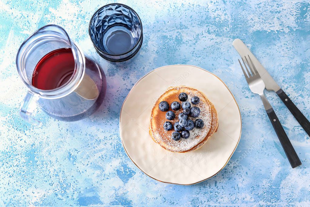 Composition with tasty pancakes, blueberries and jug of drink on table