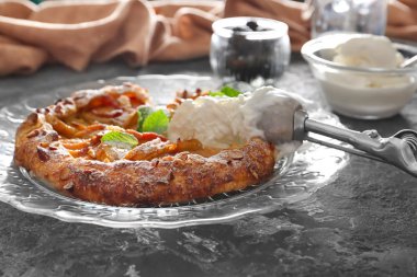 Plaka lezzetli şeftali Galette'ye ve grunge masada dondurma ile