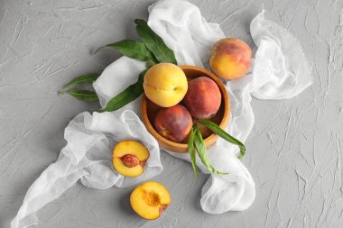 Işık tablosu üzerinde taze şeftali ile kase