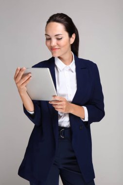 Tablet bilgisayarda gri arka plan ile güzel iş kadını