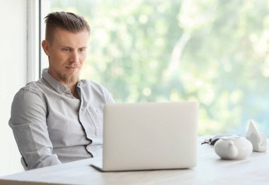 Kafede dizüstü bilgisayar ile yakışıklı serbest meslek